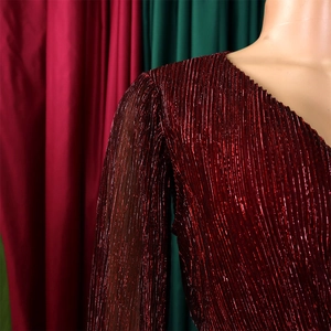 Close-up of metallic burgundy pleated fabric with shimmering texture and elegant draping