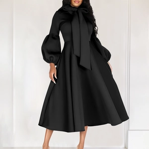 Detailed view of puff sleeves and large bow tie neckline on this black A-line maxi dress