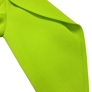 Detail shot of neon green dress showing fabric texture and fine stitching craftsmanship
