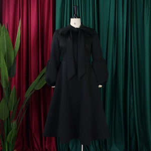 Detail showing elegant black puff sleeves and a large bow tie neck on a vintage dress