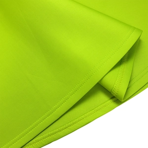 Close-up of fluorescent green fabric with precise double-needle stitching on the hem