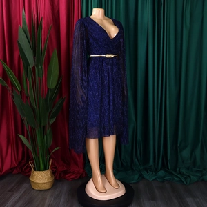 Detail of V-neck dark blue glitter dress featuring cape sleeves and a gold chain belt