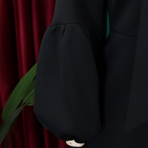 Detail of elegant puff sleeves with pleats on a black high-waist gown dress