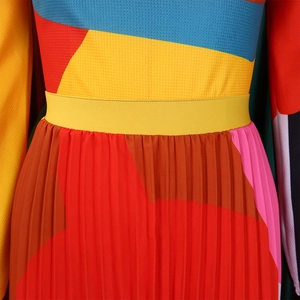 Detail of color-block pleated skirt fabric with yellow elastic waistband and mesh texture