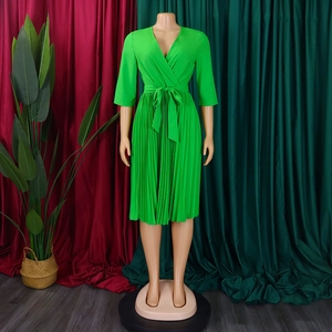 Detail of elegant bright green V-neck pleated dress with waist tie and midi length