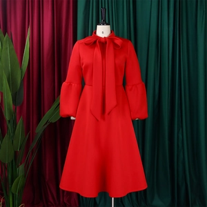 Detail of red lantern sleeve dress with oversized bow tie collar and high waist