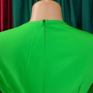 Detail of elegant green V-neck dress featuring a hidden back zipper and smooth fabric