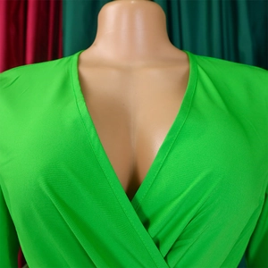 Detail of the bright green V-neck pleated texture fabric on a stylish African dress