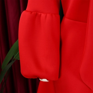 Detailed close-up of vibrant red puff sleeves and textured fabric on this elegant party dress