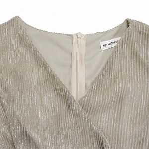 Detail of V-neckline and back invisible zipper on champagne gold metallic pleated dress