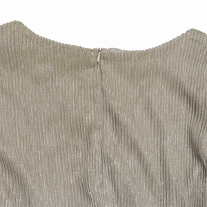 Macro shot of invisible zipper detail on champagne gold plissé fabric with lurex shine