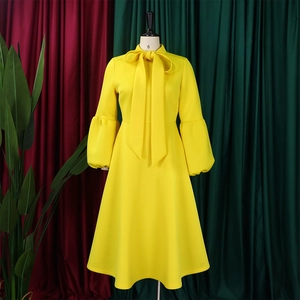 Detailed view of yellow puff sleeve midi dress with elegant bow tie neckline detail