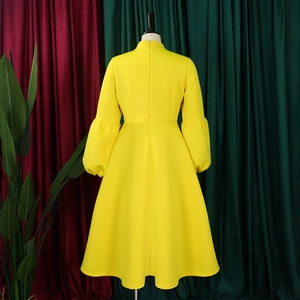 Rear view detail of high-waist yellow dress with puff sleeves and full A-line skirt