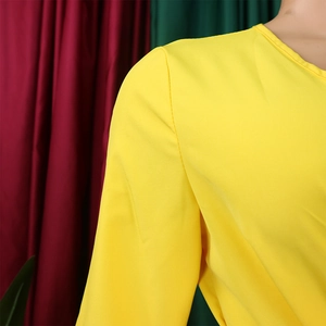 Detail view of the fine ribbed texture and pleated stitching of this bright yellow dress