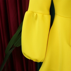 Detailed view of puff lantern sleeves on a vibrant yellow high-waisted evening dress