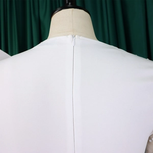 Detail of white jumpsuit featuring back invisible zipper and delicate pearl shoulder accents