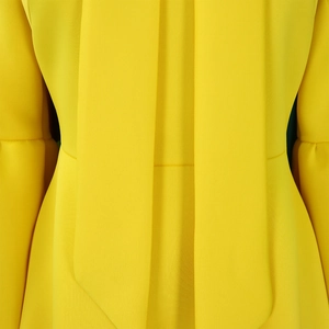 Detail of yellow plus size dress showing bow tie neckline and paneled puff sleeves