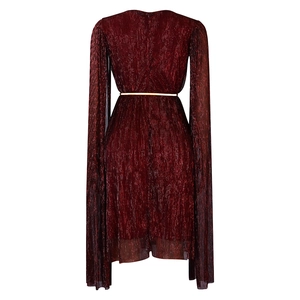 Detail of burgundy pleated dress featuring long cape sleeves and a slim gold metallic belt