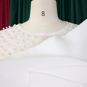 Close-up of white pearls on sheer mesh neckline of an elegant wide-leg jumpsuit