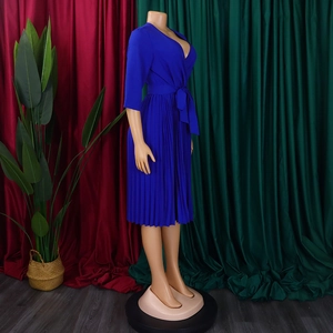 Detail of royal blue V-neck pleated dress with long sleeves and self-tie waist belt