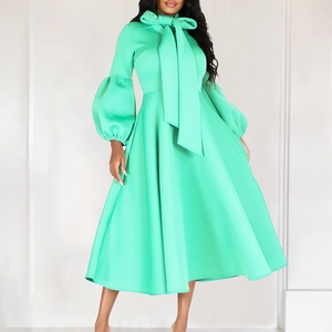 Detail of mint green A-line dress featuring a large bow neckline and puff lantern sleeves