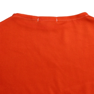 Detail of reinforced double stitching on orange mesh fabric neckline for durability