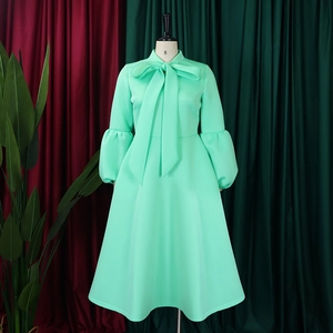 Detail of mint green lantern sleeves and elegant bow neckline on a flared dress