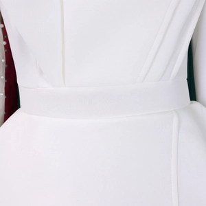 Detail of white mesh jumpsuit featuring waist pleats and elegant pearl embellishments