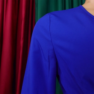 Detailed close-up of dark blue pleated dress shoulder seam and sand washed fabric texture