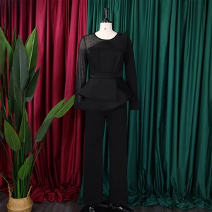 Detail of black peplum jumpsuit with mesh pearl sleeve and elegant waist ruffles