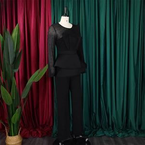 Detail of black mesh sleeve with beads and ruffled waist on elegant jumpsuit