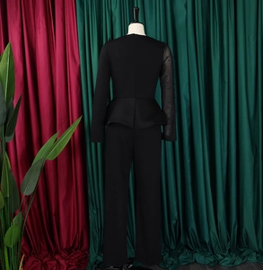 Detail view of the black peplum jumpsuit featuring mesh sleeves and beaded embroidery