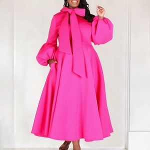 Detail of elegant fuchsia dress featuring a large bow neckline and puff lantern sleeves
