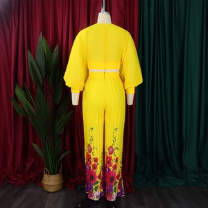 Detail of yellow pleated two-piece set with floral digital print on wide-leg pants