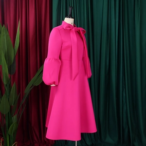 Detail of the elegant bow-tie collar and lantern sleeves on a magenta A-line dress