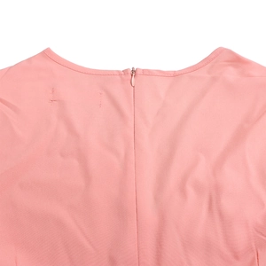 Detail of pink dress featuring a seamless invisible zipper and fine stitching on the round neck