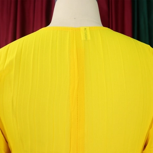 Detailed macro view of the pleated bright yellow chiffon fabric and collar texture