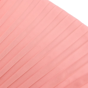 Close-up of pleated coral pink fabric texture for an elegant V-neck African dress