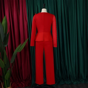Detail of red two-piece peplum top and trousers set showing beaded sleeve and waist design