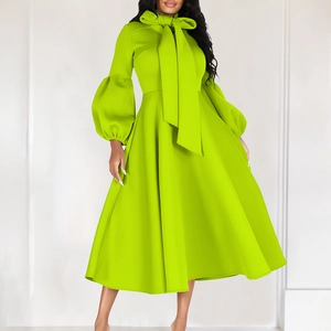 Detail of high neck tie-up bow and lantern sleeves on a vibrant lime green dress