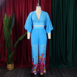 Detail of blue V-neck chiffon top and wide-leg trousers with floral print hem