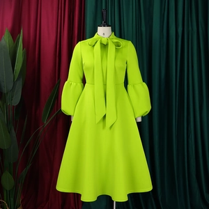 Detail of puff sleeves and bow tie neck on a vibrant green formal evening dress