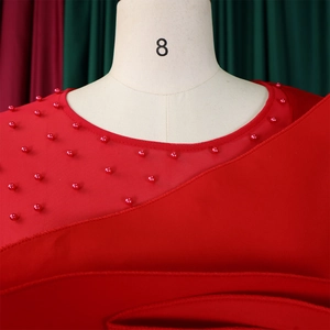Macro shot of red mesh patchwork neckline with beaded pearl embellishments on a jumpsuit