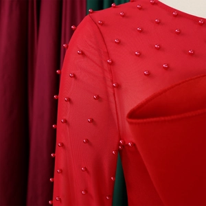 Detail of red mesh jumpsuit with hand-sewn beads and elegant round neckline