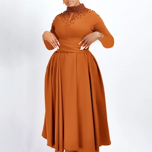 Detail of high neck caramel dress featuring hand-stitched beadwork and cutout bodice
