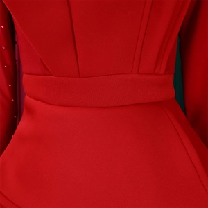 Detailed close-up of red mesh jumpsuit waist with handcrafted beadwork on sleeves