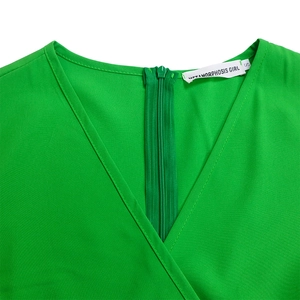 Close-up of bright green dress V-neck and high-quality invisible back zipper detail
