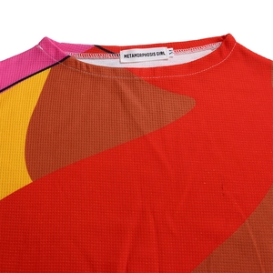 Detailed close-up of geometric print fabric and brand neck label for women's set