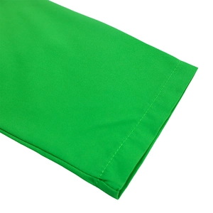 Detailed close-up of vibrant green dress hem showing precision stitching and fabric texture