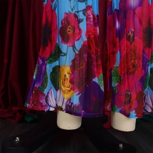 Detailed view of floral printed pleated fabric with blue base and vibrant flower patterns